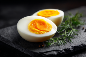 A perfectly cooked hard boiled egg sliced in half, revealing a vibrant, creamy yellow yolk with no green or grey ring around it.