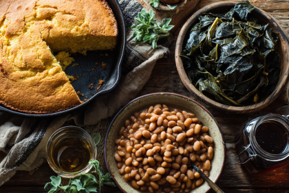 A rustic table with Appalachian cooking staples like cast-iron cornbread, soup beans, and greens.