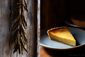 A string of dried "leather britches" (green beans) hanging next to a slice of resourceful Appalachian vinegar pie on a plate.