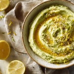 Creamy avocado honey mash with olive oil and lemon zest in a ceramic bowl